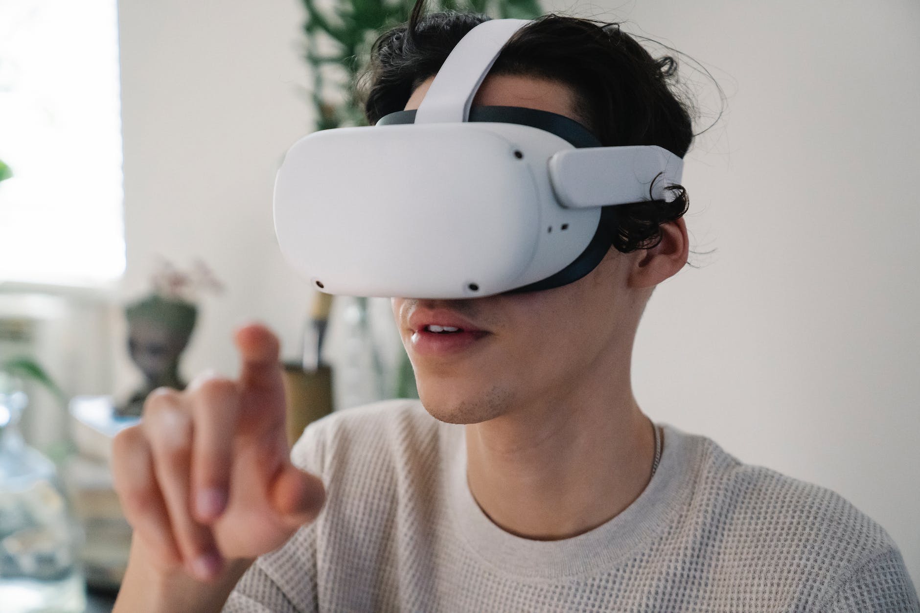 young male interacting with virtual reality headset in apartment
